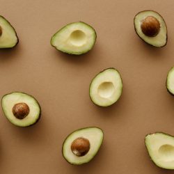 Mehre Bio-Avocados halbiert mit und ohne Kern von oben