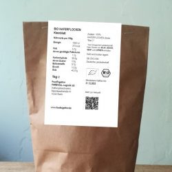 Bio Haferflocken Kleinblatt abgepackt in brauner Papiertüte mit Nährwertangaben auf weißem Zettel
