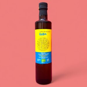 Edem Oliven&ouml;l 0,5l, gelbes Etikett mit blauer Schrift Flasche vor rosa Hintergrund