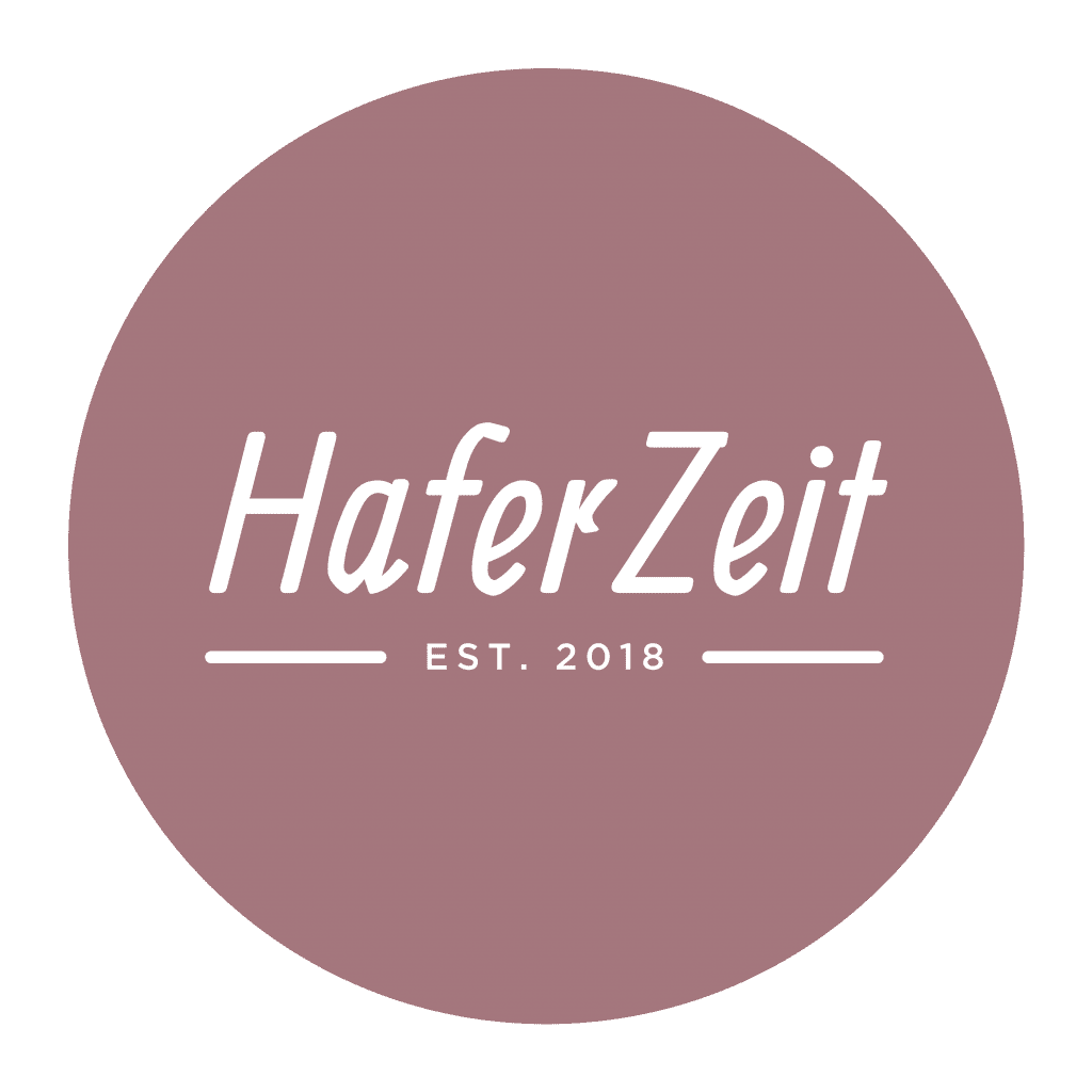 Logo HaferZeit MüsliManufaktur in weißer Schrift auf burgunderrotem Grund